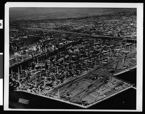 Aerial view of Long Beach showing a number of oil derricks, ca.1920