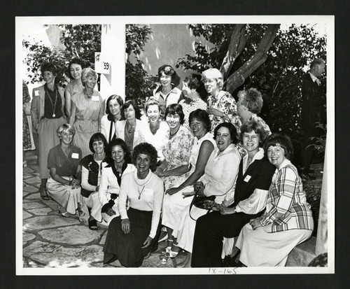 Scripps alumnae sitting together by a class of '59 sign in Margaret Fowler Garden, Scripps College