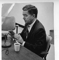 Dr. James V. Lowry, Director, California Department of Mental Hygiene, with spool of tape on tape recorder in foreground