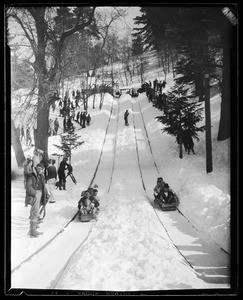 People sliding down toboggan slopes at Big Pines Camp