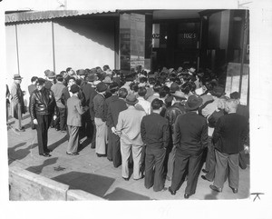 "In preparation for their removal to reception centers and employment projects in the interior. Japanese aliens and Japanese-American citizens are pictured registering at downtown office."--caption on photograph