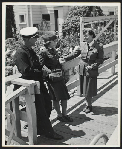 Two members of A.W.V.S. (American Women's Voluntary Service) at a fire boat with an unidentified fire crew
