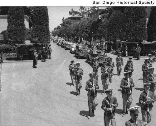 Marching band preceding a line of cars at the 1935 Exposition