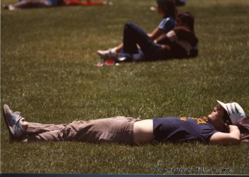 Student stretched out on Campus Green