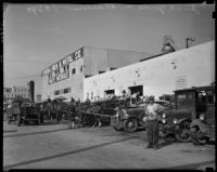 Man stands in front of a row of automobiles at a junk yard and sale outside Eureka Iron & Metal Co., Los Angeles