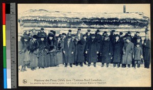 Men and women in long coats and hats standing outside a log church, Canada, ca.1920-1940