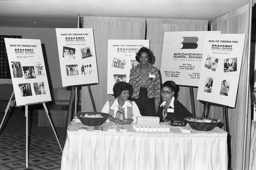 Broadway Federal Savings and Loan staff sitting at their vendor booth, Los Angeles, 1974