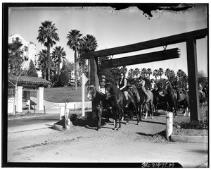 Horseback riders near the entrance to a bridle path in Beverly Hills
