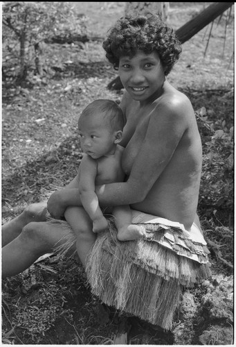 Young woman in short fiber skirt, holding infant