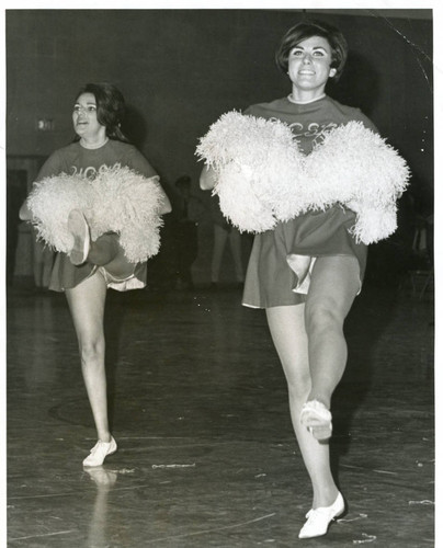 Two cheerleaders in routine, 1960s