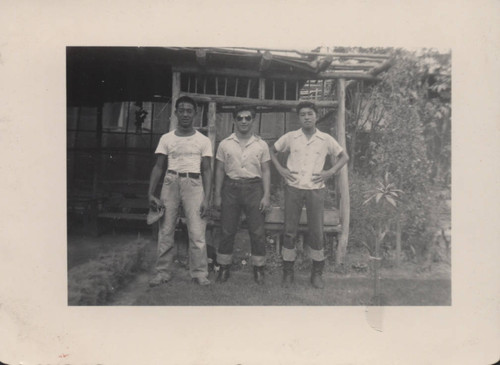 Three men standing in front of wooden garden bower in the garden at Poston incarceration camp