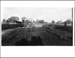 View of a lawn being watered, showing a horse-drawn streetcar on Garfield Avenue in Alhambra, ca.1888