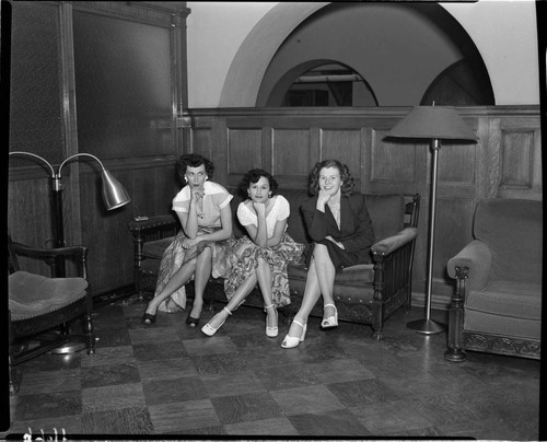 Three young ladies seated in lobby with hands resting their chins