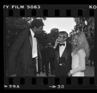 Earvin "Magic" Johson speaking with Bo Hopkins and an unidentified women at a City of Hope party at Pickfair honoring Jerry Buss, Beverly Hills, 1981
