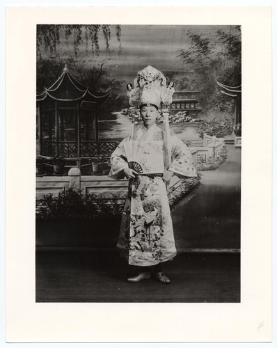 Male actor in classical gown with headdress and fan /
