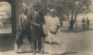 Imwiko, one of Lewanika's sons, with two of his women in front of Sesheke chapel