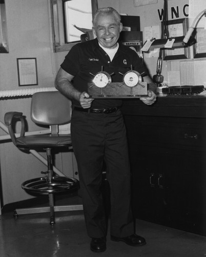 Joseph Clarke, who at this time was the captain of the D/V Glomar Challenger (ship) for the Deep Sea Drilling Project, holding gift given to him by the ship's crew. 1983