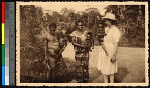 Female missionary standing with female leprosy victims and their children, Congo, ca.1920-1940