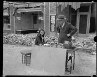 Man and woman conducting business (?) on the street after the Long Beach earthquake, Southern California, 1933
