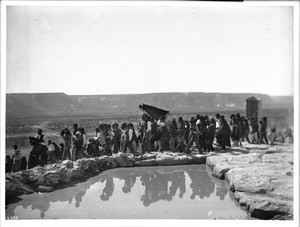 Procession of men next to the reservoir during the Fiesta de San Esteban (Saint Stephen), Acoma Pueblo, New Mexico, 1896