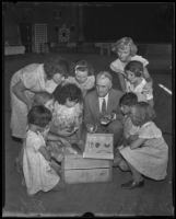 Dr. William L. Lloyd, naturalist, showing a collection of stuffed birds and other specimens to his young audience, Los Angeles, 1935