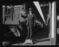Harry Frank Guggenheim poses next to train
