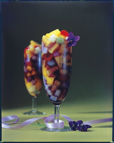 Two glasses of fruit cocktail with ribbon and violets