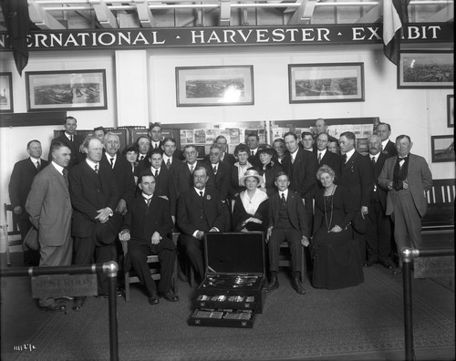 Group of people behind a display of silverware at the International Harvester Company’s exhibit