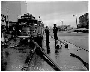 Bus versus auto accident at 1st and Hill Streets - fire hydrant in the street - wreckage of signal is under bus, 1958