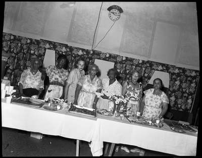 Group of women standing behind potluck buffet table