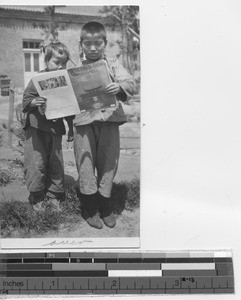 Two children reading a Maryknoll magazine at Fushun, China, 1928