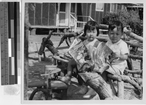 Two young children reading books outside, Jerome Relocation Center, Denson, Arkansas, ca. 1942