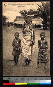 Woman with pipe standing by two young boys, Congo, ca.1920-1940
