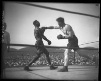 Boxer Tiger Flowers deflecting a blow from Eddie Huffman in Los Angeles, Calif., 1926