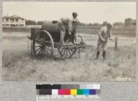 The army water caisson purchased from war department store in Texas by Principal Williams of Lower Lake High School, who is doing the pumping. Farm Advisor Barnard holding the nozle