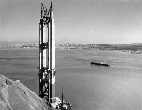 [North tower of Golden Gate Bridge with San Francisco skyline in background]
