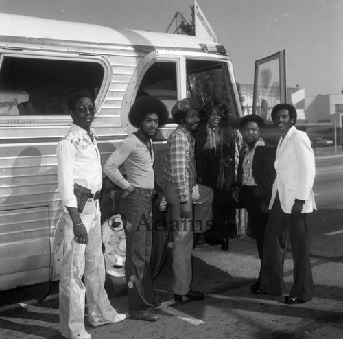 Musicians stand next to a bus, Los Angeles, 1975