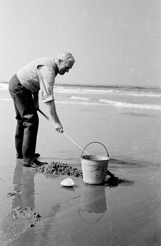 Wesley Roswell Coe (1869-1960) an invertebrate zoologist and marine biologist whose studies at ran the gamut, from investigations into embryology, physiology and morphology. He was especially known for his research on bathypelagic forms. He is shown here working on the beach near the Scripps Institution of Oceanography. Circa 1948