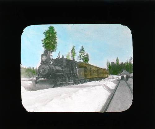Railroad train in snow at Stirling City, hand colored lantern slide