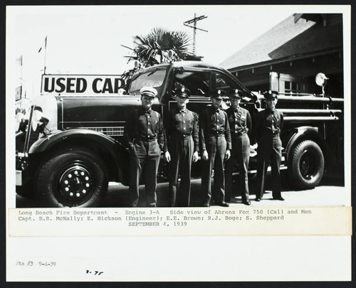 Firefighters stand by fire engine 3-A (Ahrens-Fox 750) in front of Station No. 3, 526 E. Anaheim St