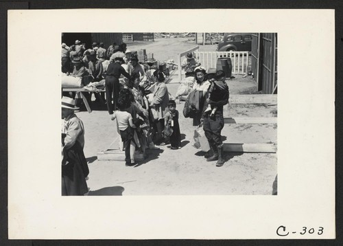 Turlock, Calif.--These evacuees of Japanese ancestry have just arrived at this Assembly Center and are awaiting the inspection of their