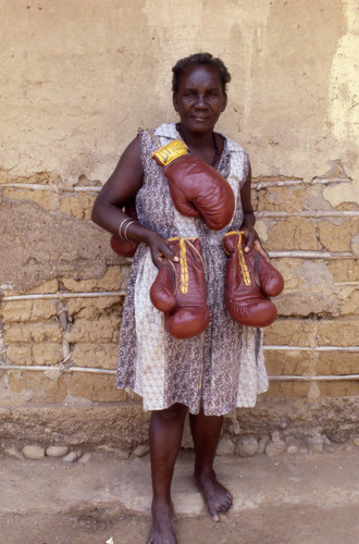 Woman with boxing gloves hanging from her neck, San Basilio de Palenque, 1976