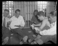 Murder suspect David H. Clark playing cards with other prisoners in jail cell in Los Angeles, Calif., 1931