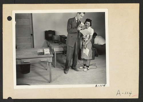 Poston, Ariz.--Florence Mori, evacuee of Japanese ancestry at this War Relocation Authority center, with Mr. Huntley of the CBS in a nationwide hookup. Photographer: Clark, Fred Poston, Arizona