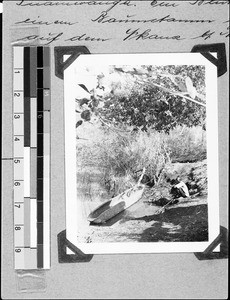 A man crouching beside a boat, Msangano, Tanzania, 1936