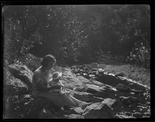 Woman and baby seated near stream, Santa Monica, circa 1922