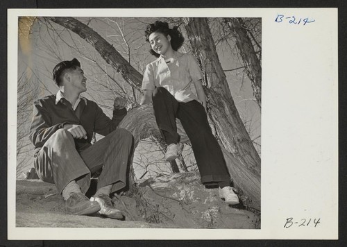 Takeshi Shindo, Reporter for the Manzanar Free Press, and his girl friend Toshiko Mikami, enjoy a pleasant afternoon at the picnic ground at this War Relocation Authority Center, for evacuees of Japanese ancestry. Photographer: Stewart, Francis Manzanar, California