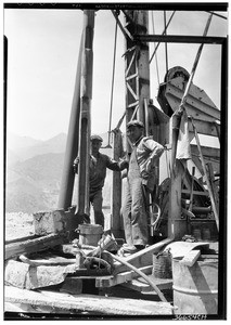 San Gabriel Dam construction, showing two men on a machine, 1936