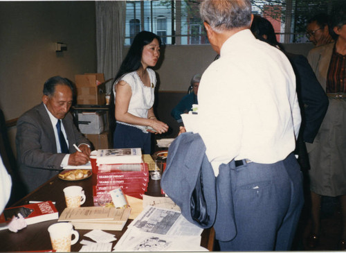 Harry Ueno autographing Manzanar martyr