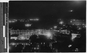 Night view of Hong Kong harbor looking at Kowloon, China, ca.1920